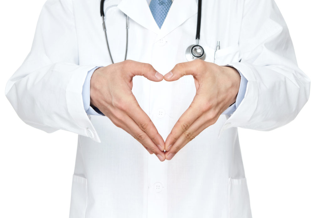 Doctor showing heart shape isolated on white background
